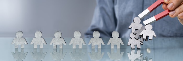 Ecommerce strategies: person using a magnet to get metal figurines shaped like people