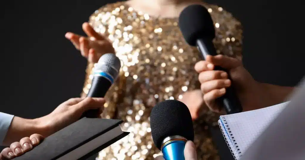 Celebrity being interviewed by reporters with microphones, representing media influence in celebrity marketing.